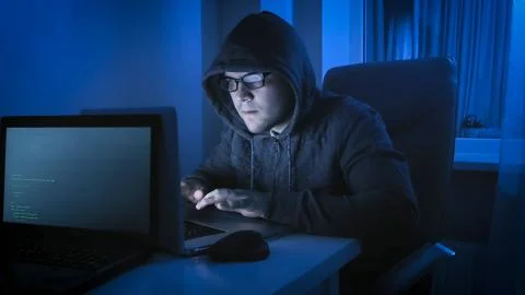 Computer hacker criminal coding virus on latop at night Stock Photos