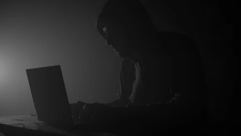 Computer hacker in hoodie with laptop in dark room Stock Footage 104051468