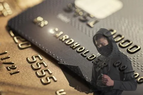 Computer hacker with laptop against background with credit cards. Stock Photos