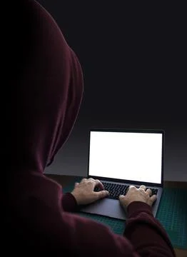 Computer hacker with a laptop in darkness 库存照片