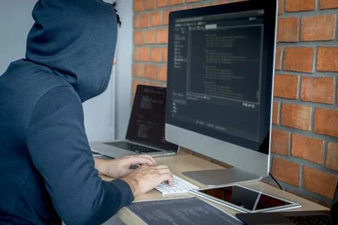 Computer hacker or cyber attack concept, Dangerous hooded hacker using multip 스톡 사진