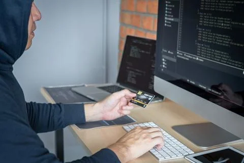 Computer hacker or cyber attack concept, Dangerous hooded hacker using multip 写真素材