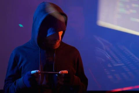 Computer hacker using smart phone Foto stock