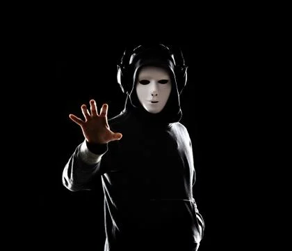 Computer hacker in white mask and hoodie. Obscured dark face. Data thief Stock Photos
