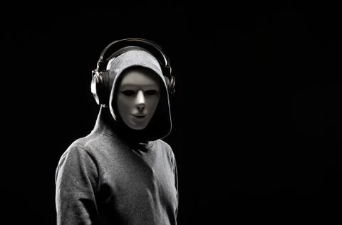 Computer hacker in white mask and hoodie. Obscured dark face. Data thief Stock Photos