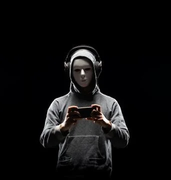 Computer hacker in white mask and hoodie. Obscured dark face. Data thief 스톡 사진