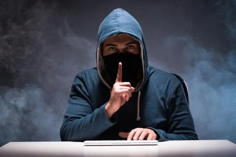 Computer hacker working in dark room Stock-Fotos