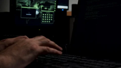 Computer hacker working in shadowy backroom coding. Stock Footage 107774285