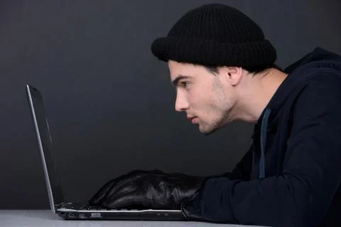Computer hacking. Angry young men in balaclava gesturing and looking at the comp 写真素材