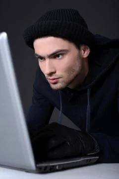 Computer hacking. Angry young men in balaclava gesturing and looking at the comp 写真素材