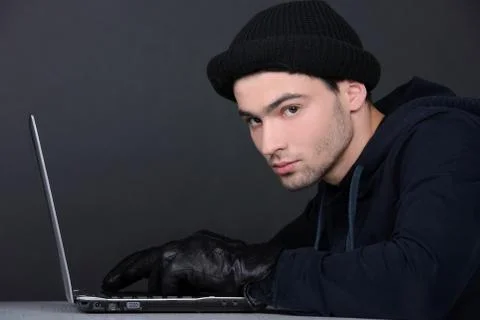 Computer hacking. Angry young men in balaclava gesturing and looking at the comp 写真素材