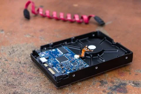 Computer hard drive lies on a table in an electronics repair shop Stock Photos
