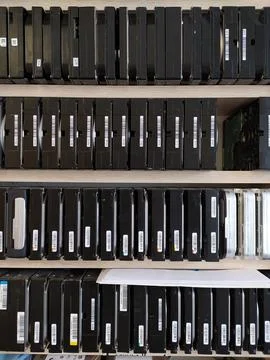 Computer hard drives in neat rows on shelves in computer repair shop. Stock Photos
