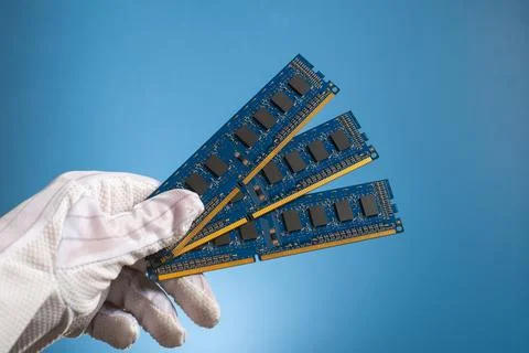 Computer hardware DDR RAM board for PC in hand in glove on blue background Stock Photos