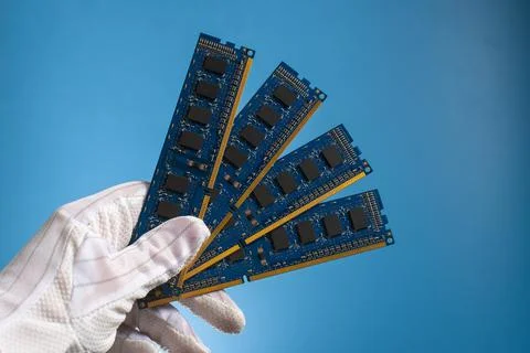 Computer hardware DDR RAM board for PC in hand in glove on blue background Stock Photos