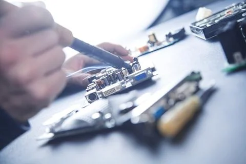 Computer hardware engineering. Engineer soldering computer motherboard Stock Photos