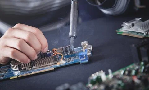 Computer hardware engineering. Engineer soldering computer motherboard Foto stock
