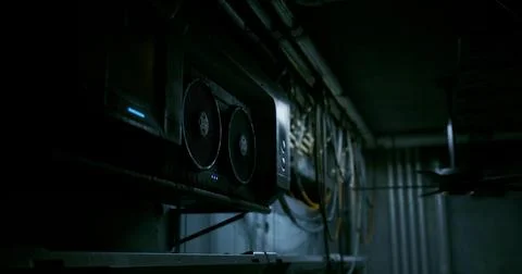 Computer hardware setup in a dimly lit server room with cooling fans Illustrazione stock