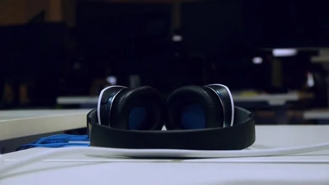 Computer headphones lie on the table, the background is a man Stock Footage 81722282