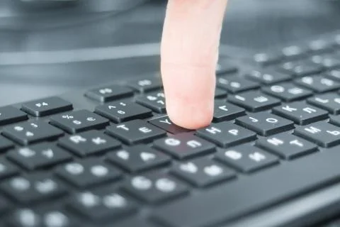 Computer keyboard and finger Stock Photos