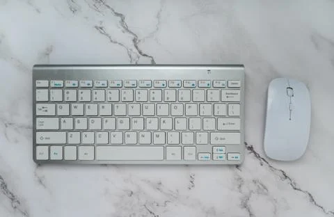 Computer keyboard and mouse isolated on white marble background.Top view with Stock Photos
