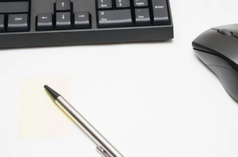 Computer keyboard and mouse, pen, Yellow sticky note isolated on white backgr Stock Photos