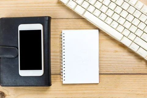 Computer keyboard and note book with a mobile phone Stock Photos