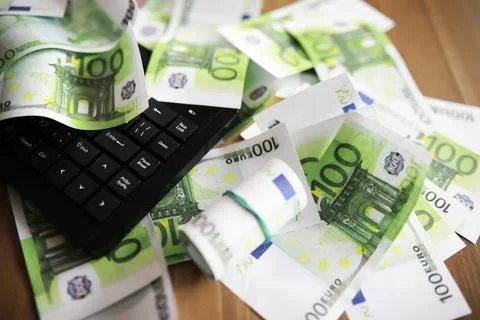 Computer keyboard and a scattering of 100 euro bills on the table. The work.. Stock Photos