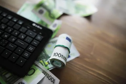 Computer keyboard and a scattering of 100 euro bills on the table. The work.. Stockfoto's