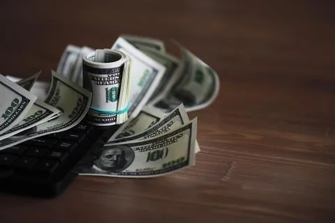 Computer keyboard and a scattering of 100 dollar bills on the table. The wo.. Stock Photos