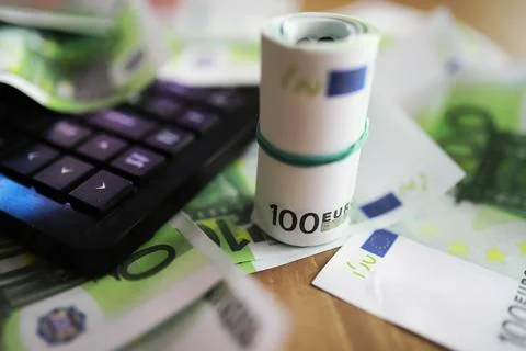 Computer keyboard and a scattering of 100 euro bills on the table. The work.. Stockfoto's