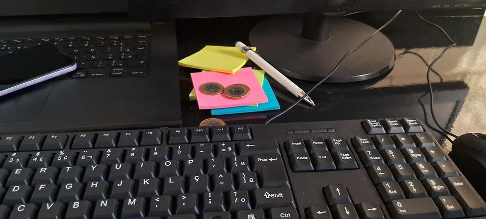 Computer keyboard and sticky notes on desk. Office workspace with stationery and Foto stock