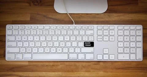 Computer keyboard with black friday key and shopping cart. Copy space and woo Fotos de archivo