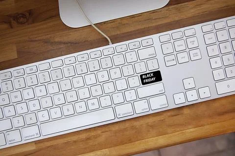 Computer keyboard with black friday key and shopping cart. Copy space and woo Fotos Stock