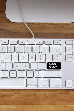Computer keyboard with black friday key and shopping cart. Copy space and woo Fotos Stock