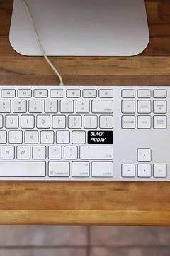 Computer keyboard with black friday key and shopping cart. Copy space and woo 스톡 사진
