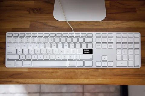 Computer keyboard with black friday key and shopping cart. Copy space and woo Fotos de archivo