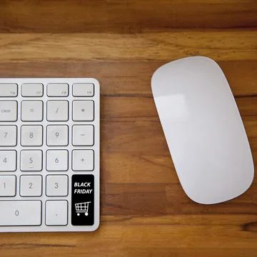 Computer keyboard with black friday key and shopping cart. Copy space and woo Fotos Stock