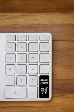 Computer keyboard with black friday key and shopping cart. Copy space and woo Fotos Stock