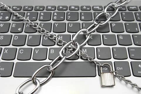 A computer keyboard with a chain and a padlock, cybersecurity concept Stock Photos