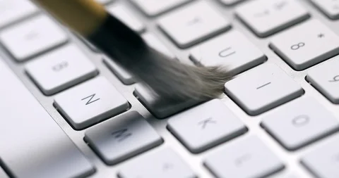 Computer keyboard cleaning with brush, closeup  detail Vidéo 103174507