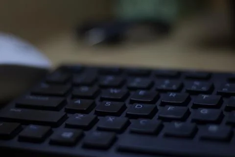 Computer keyboard closeup in black backlight Stock Photos