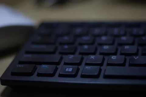 Computer keyboard closeup in black backlight Stock Photos