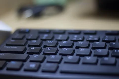 Computer keyboard closeup in black backlight Stock Photos