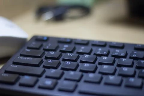 Computer keyboard closeup in black backlight Stock Photos
