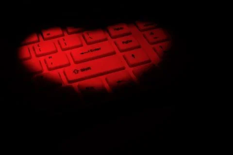 A computer keyboard is highlighted in red in the shape of a heart. The concep Stock Photos
