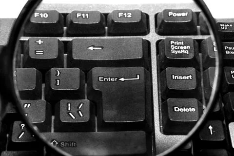 Computer keyboard with magnifying glass Stock Photos