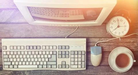 Computer keyboard with mouse and coffee on wooden desk Stock Photos