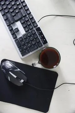 Computer keyboard mouse and a cup of coffee on a white table Foto stock