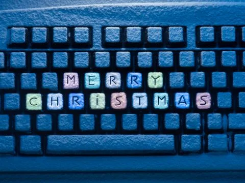 Computer keyboard with multicolored text merry christmas on buttons covered with 스톡 사진